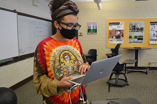 masked student on a laptop