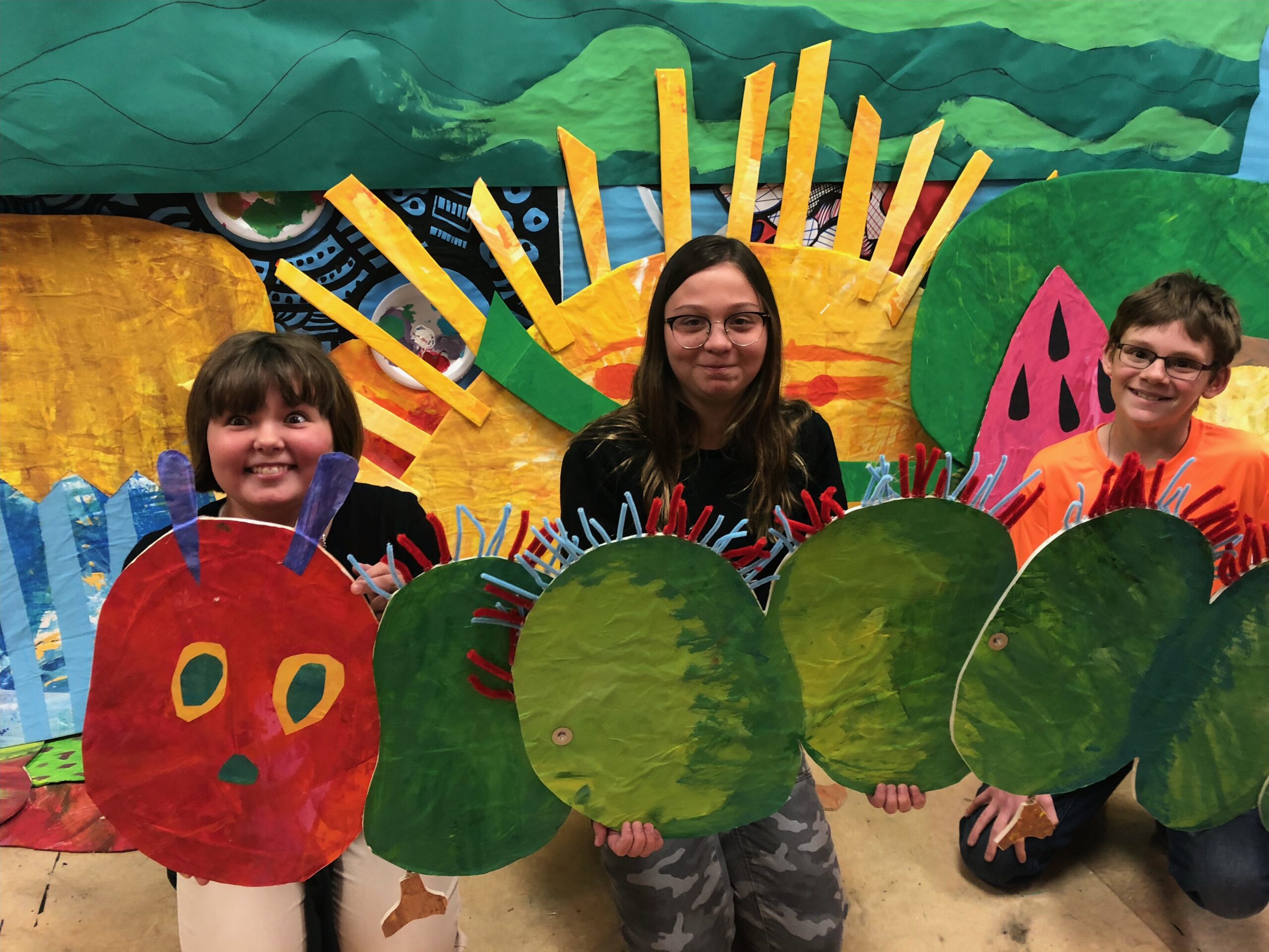 Children displaying Caterpillar art